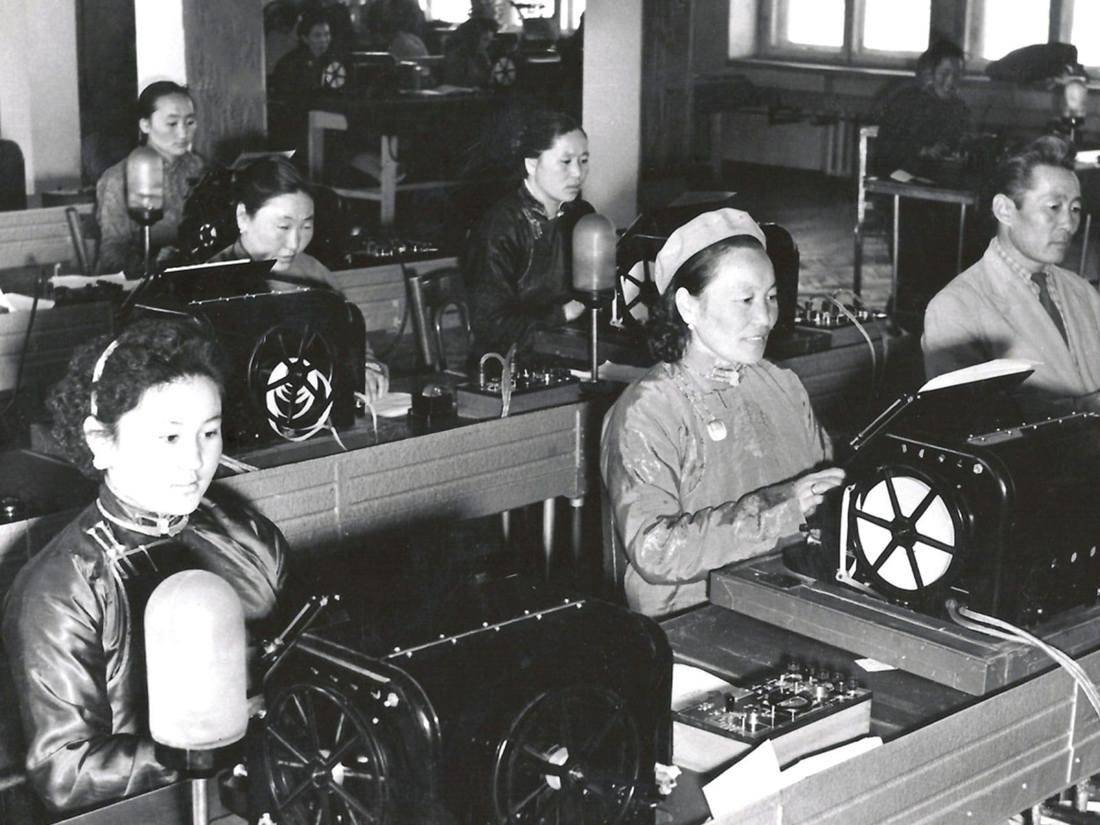 Operators working at telegraph machines in a communications room.