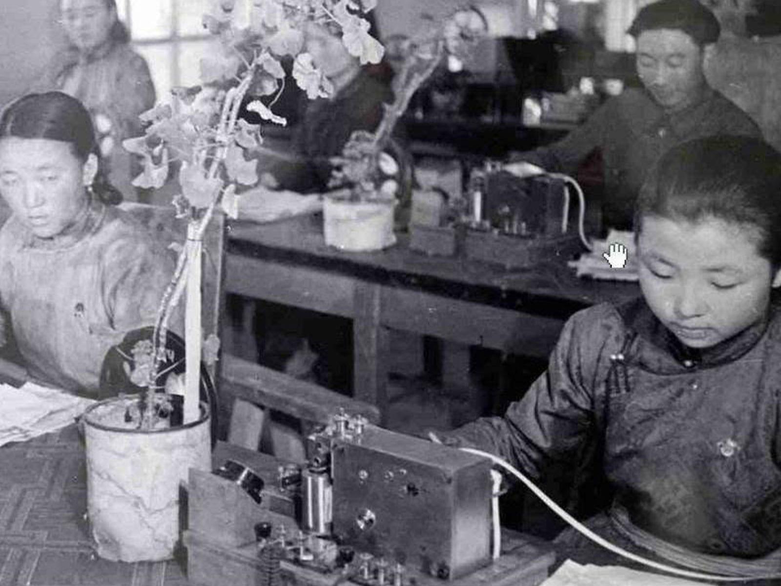 Telecommunications operators working at desk equipment.